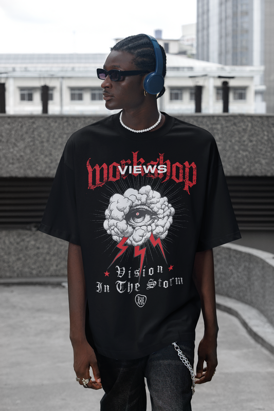 Person wearing a black t-shirt with graphic design and text, standing on a rooftop.